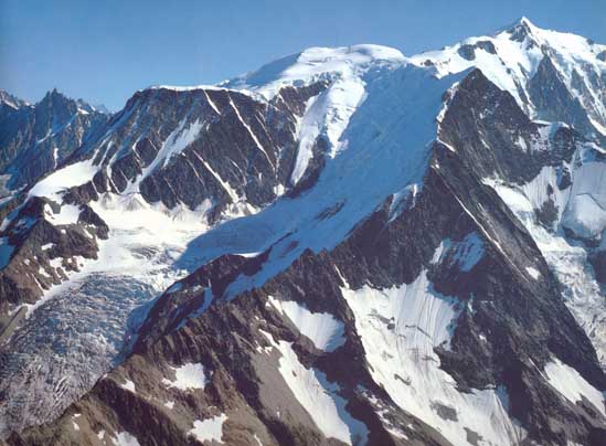 Widok na cały masyw Mont Blanc od strony zachodniej. Fot. Willi Burkhardt. Z lewej strony widocznego lodospadu, poprzez skalne żebra Aig du Gouter prowadzi klasyczna droga na wierzchołek.